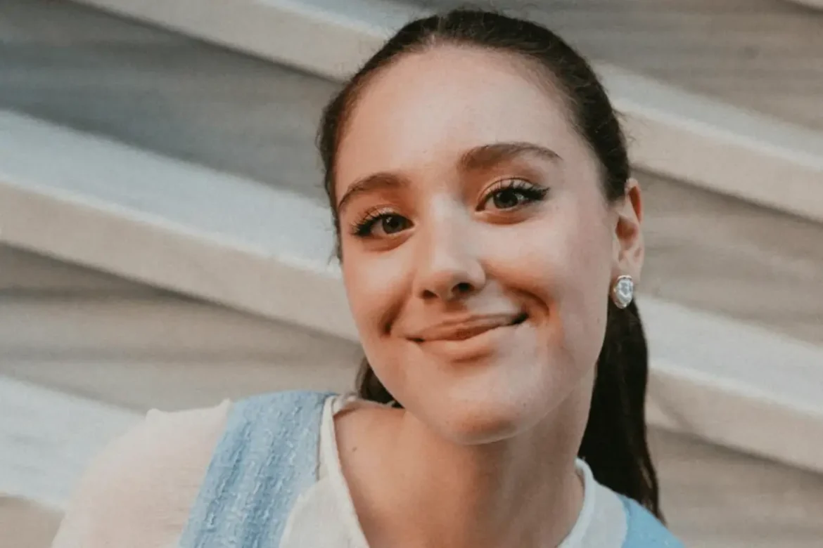 Young woman smiling into camera.