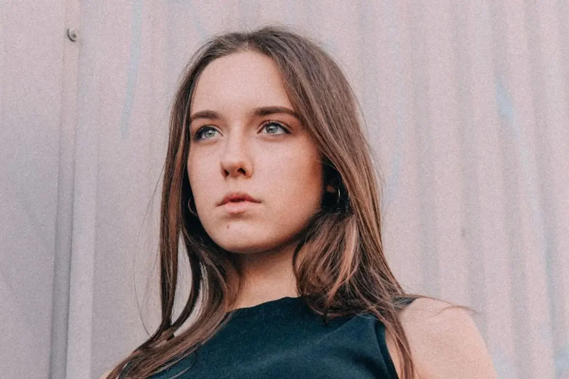 Young woman standing outside posing for camera.