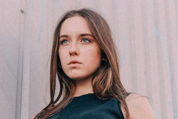 Young woman standing outside posing for camera.