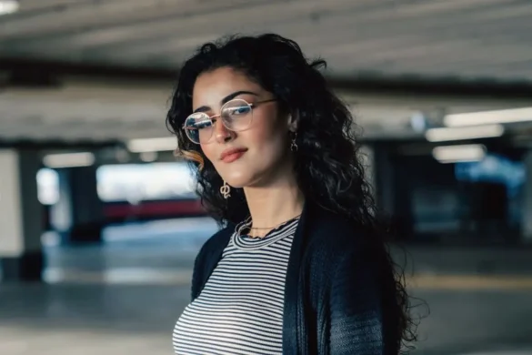 Young woman in parking garage, smiling at the camera.