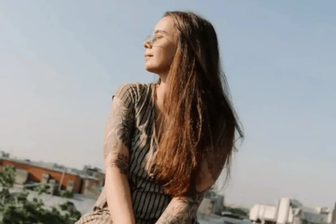 Young woman sitting on a terrace enjoying the sun.