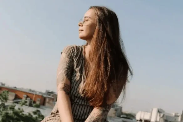 Young woman sitting on a terrace enjoying the sun.