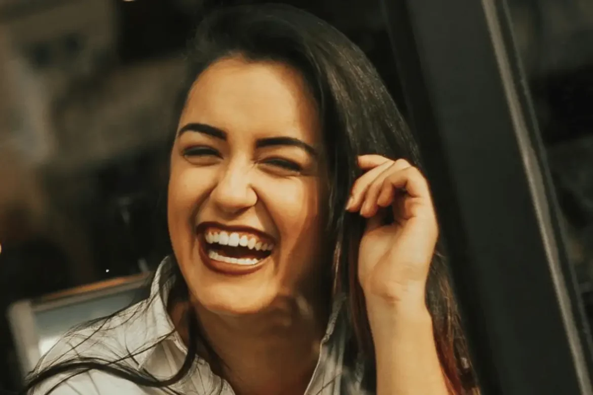 Woman laughing while in conversation.