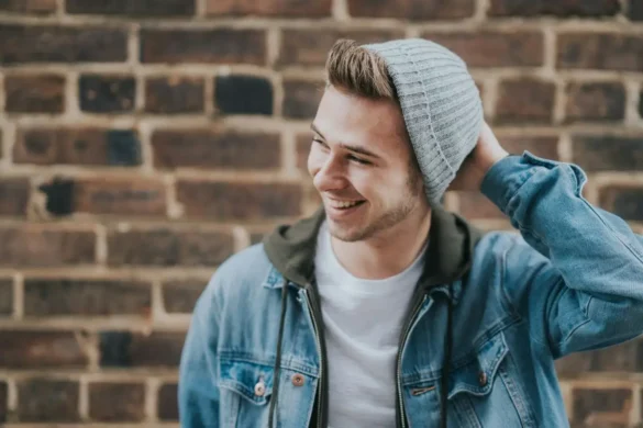 Smiling guy standing outside in front brick wall.