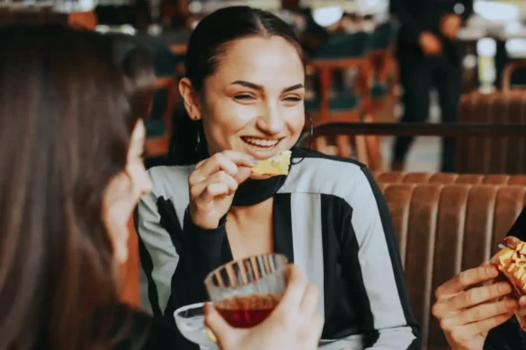 Woman laughing while having dinner with friends.